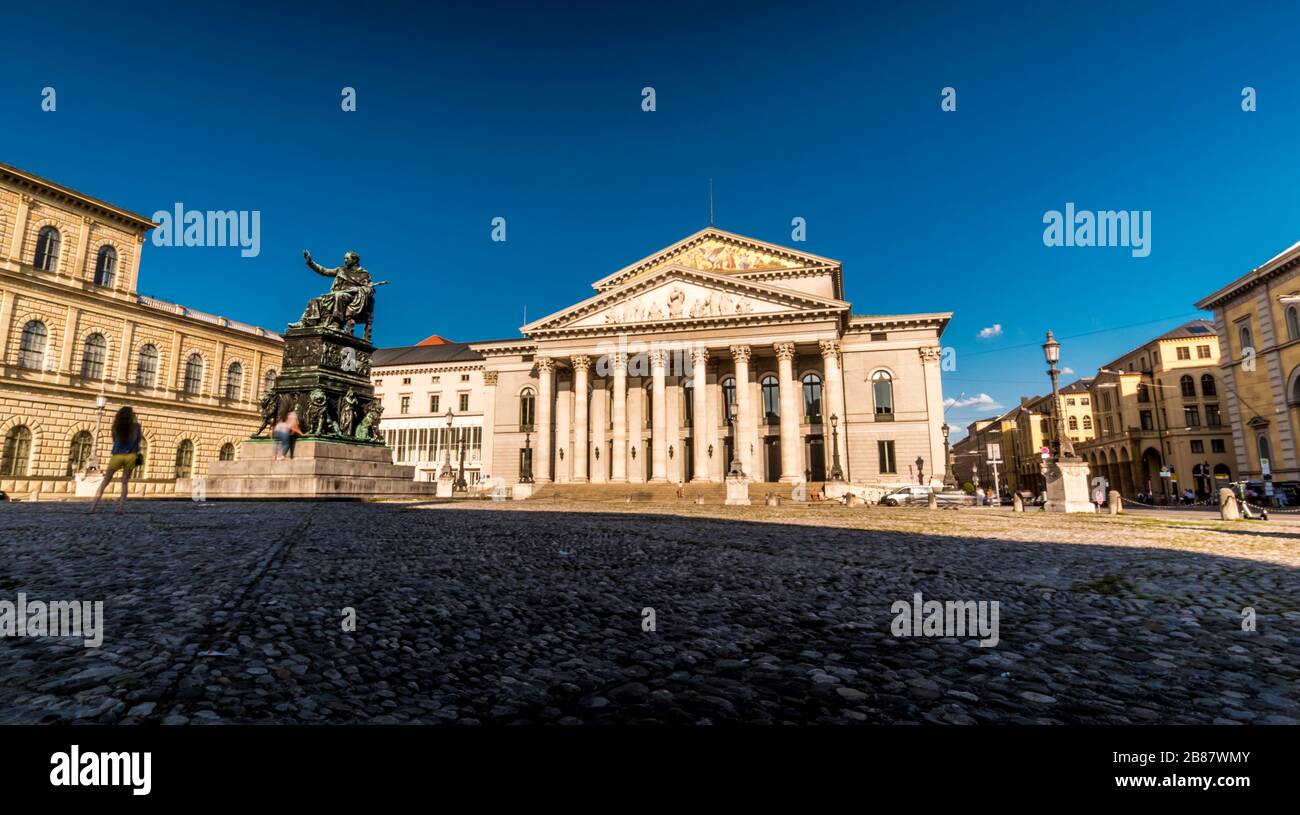 Munich 2019. Long exposure of tourists passing in front of the Bavarian National Theater located on Max-Joseph-Platz. We are in the afternoon of a war Stock Photo