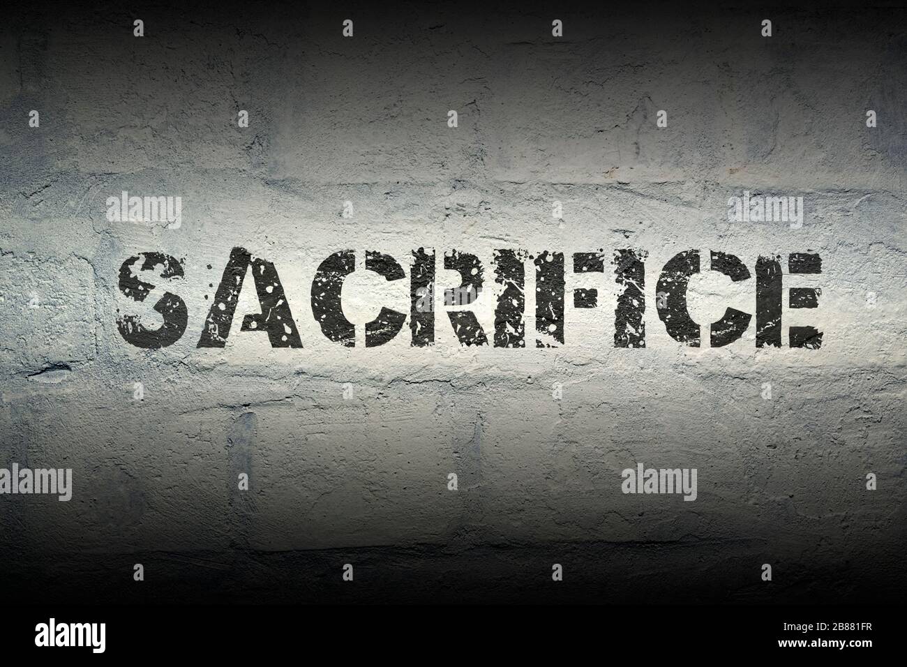 sacrifice stencil print on the grunge white brick wall Stock Photo