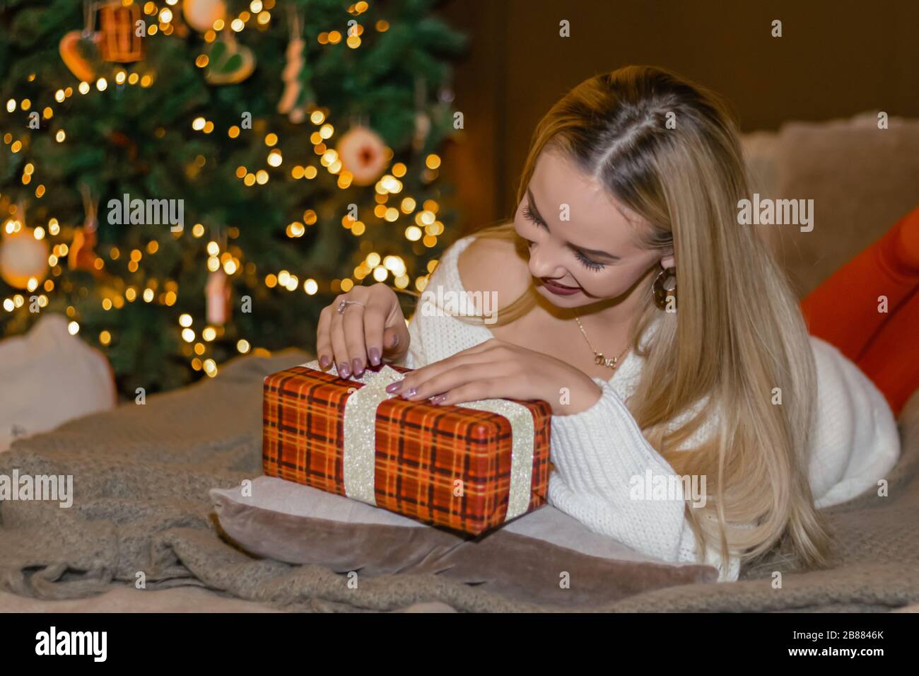 happy girl opening Christmas presents at home photo Stock Photo