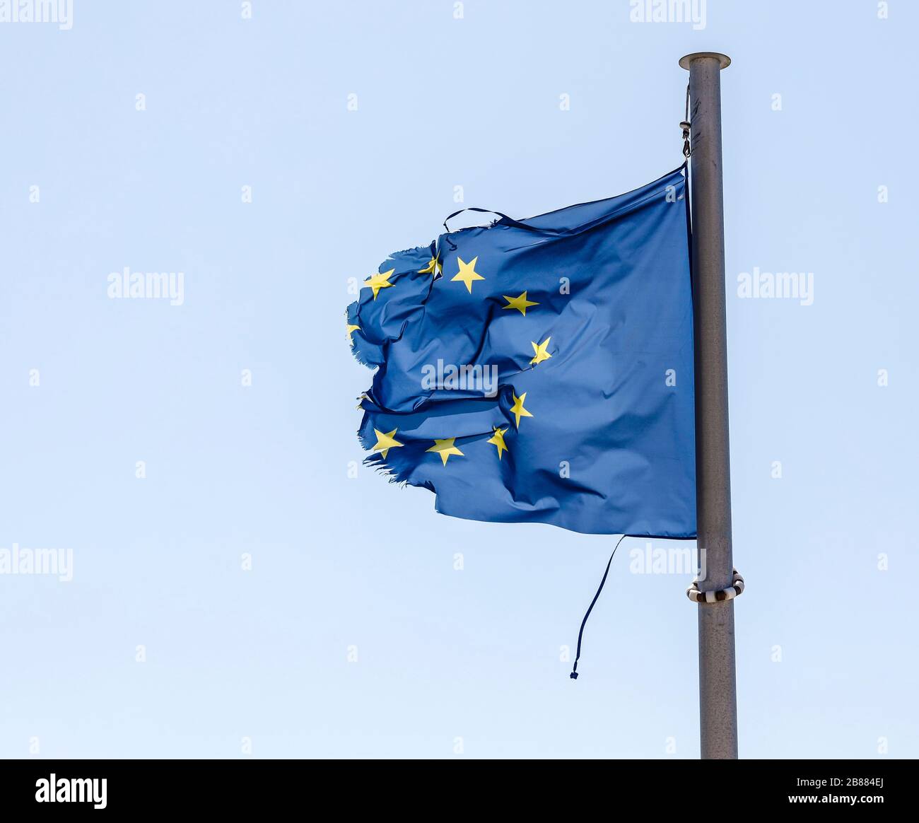 Torn European flag fluttering in the wind at the flagpole, symbolic image of Europe in crisis, Germany Stock Photo