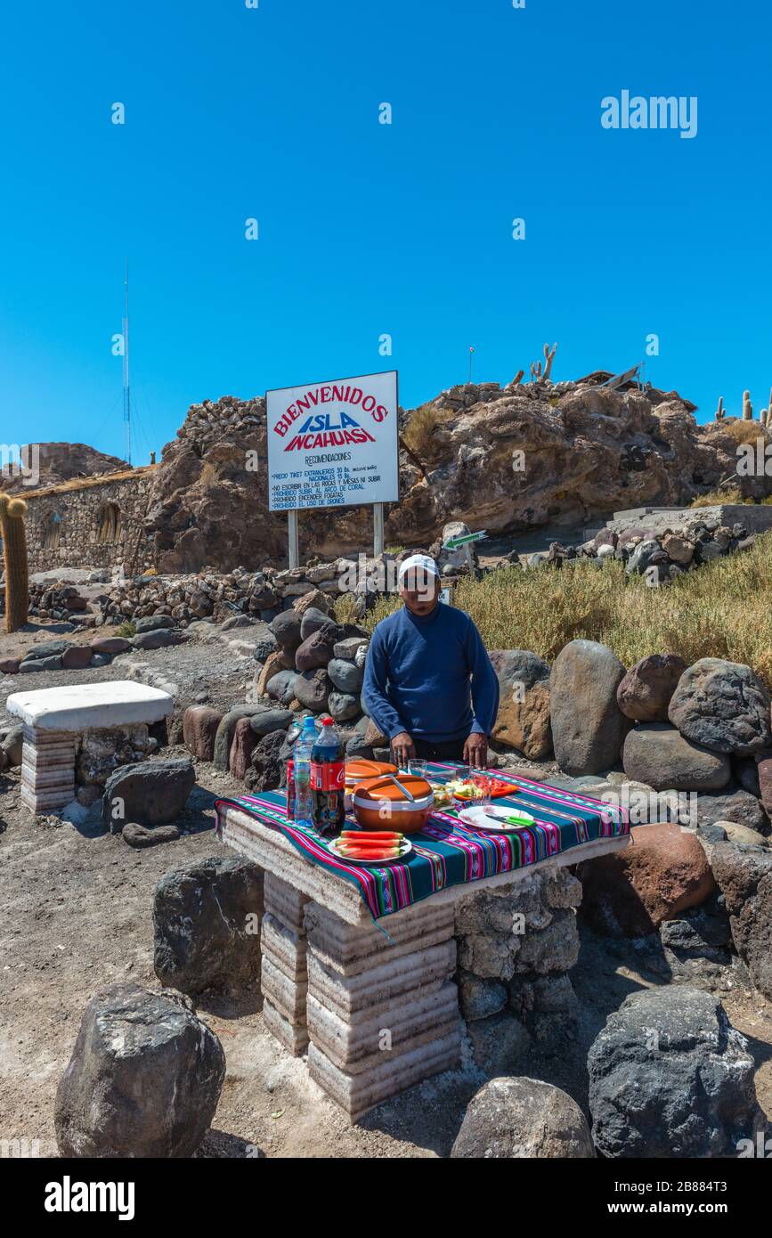 Guide preparing food, Table made of salt blocks, Isla Incahuasi, Inca House Island, Salar de Uyuni, Potosi Department, Southwest Bolivia Stock Photo