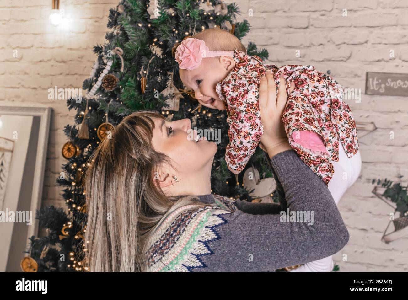 Happy young mother with her sweet baby at christmas photo Stock Photo