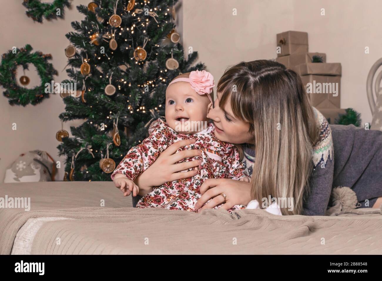 Happy young mother with her sweet baby at christmas photo Stock Photo