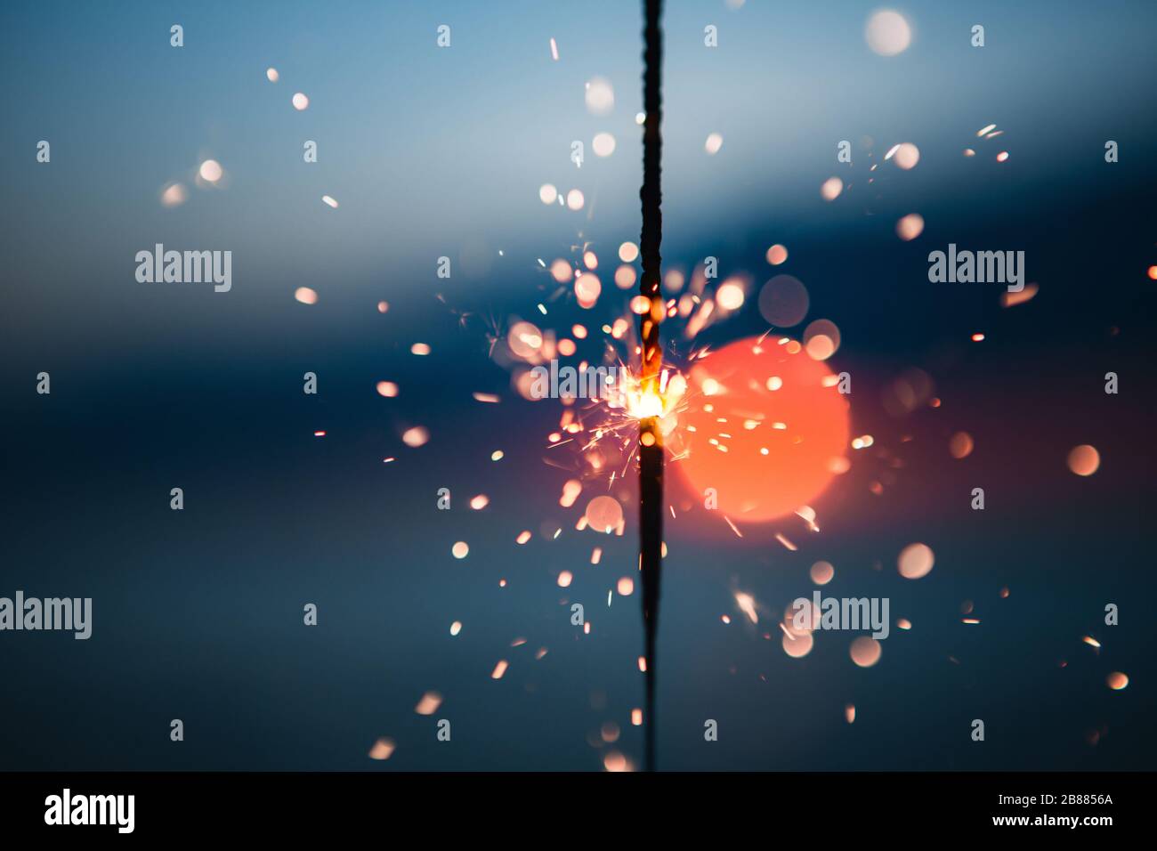 Lighting off a Fourth of July Sparkler celebration on a beach at sunset Stock Photo