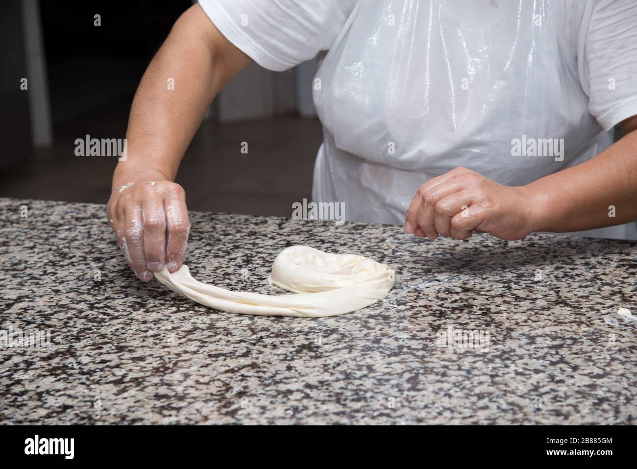 close up of female hands kneading dough and making banitsa - typical ...