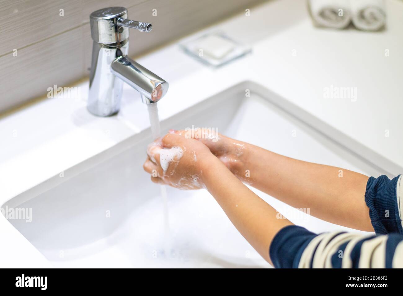Toddlers wash their hands in a washstand in kindergarten. Concept of hygiene, professional childcare stock photo Stock Photo