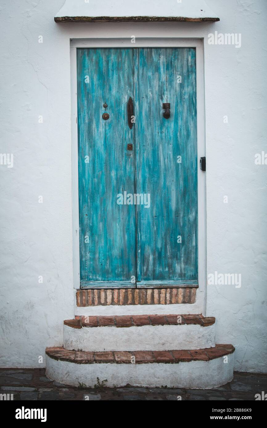 Vintage Retro Entrance Facade with Blue Painted Wooden Door and Stairs in Vejer de la Frontera, Cadiz, Spain Stock Photo