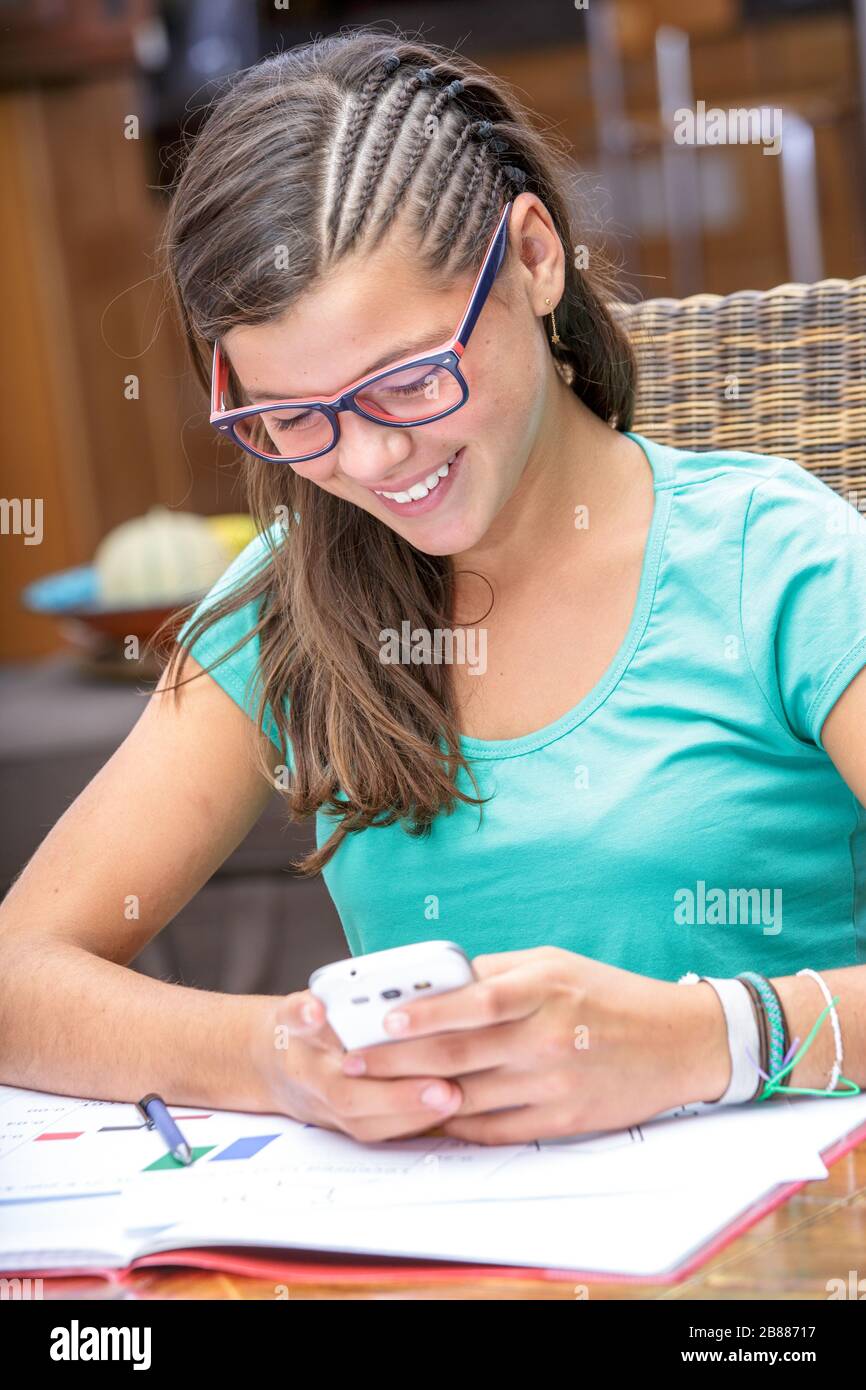 pretty student doing homework while sending a text message Stock Photo ...