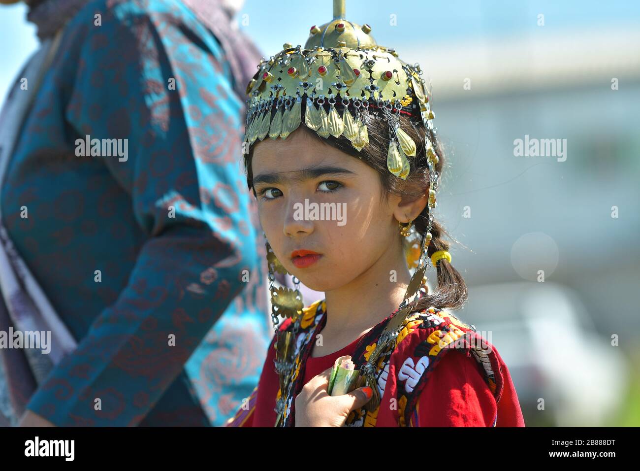 TURKMENISTAN, ASHGABAT - MAY 1, 2019: Day of turkmen racehorse. Public. Girl in a traditional clothes and head decoration. Stock Photo