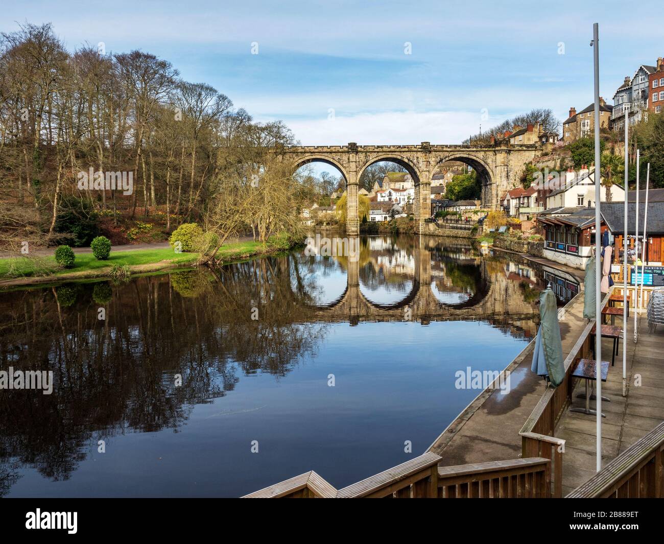 The Victorian railway viaduct reflected in the River Nidd in early spring at Knaresborough North Yorkshire England Stock Photo