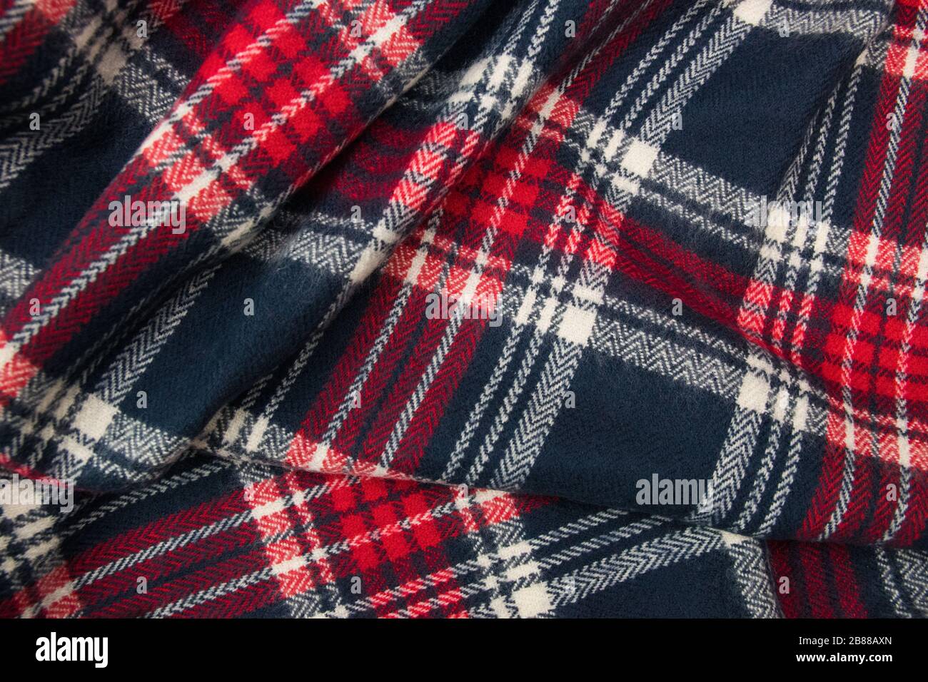Winter cashmere scarf. Blue, white, red cage texture fabric. Textile warm dark knitted cloth background. Stock Photo