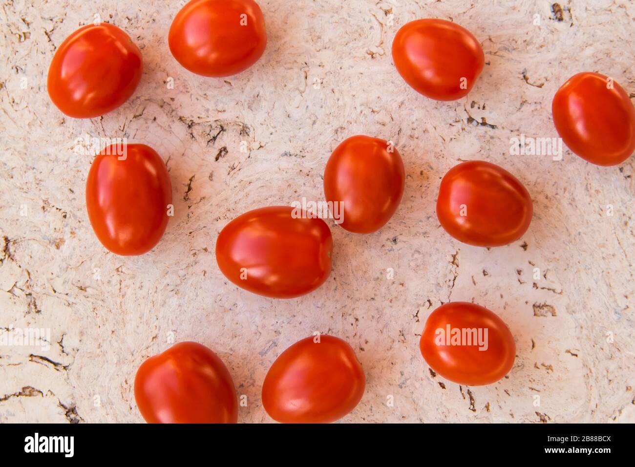 Red fresh tomatoes on the natural cork background. Stock Photo