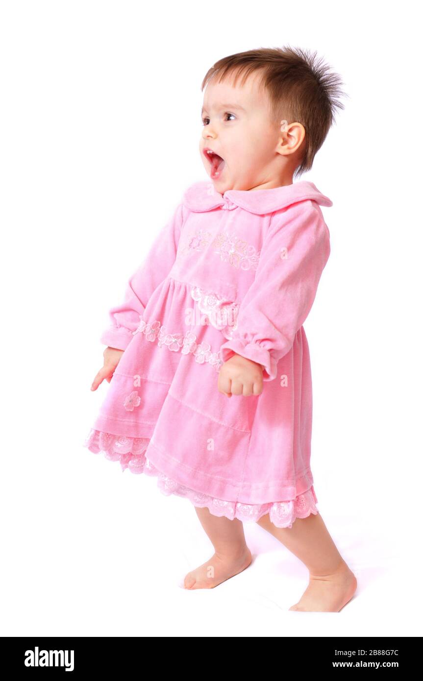 Sitting laughing pretty little one year baby girl with open mouth in pink dress fun holding toe. Isolated on white background Stock Photo Alamy