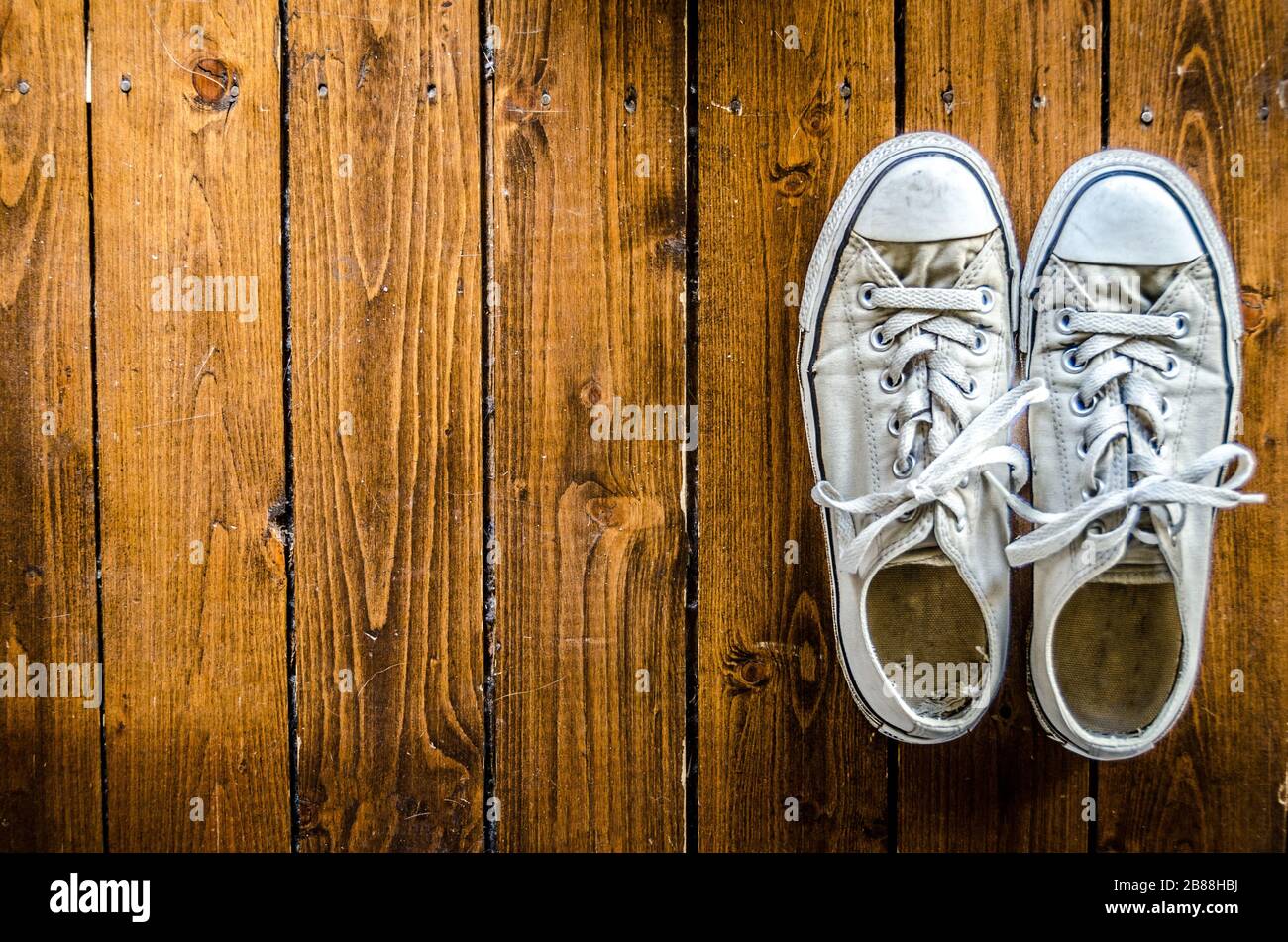 White Womans Canvas Sneakers on Hardwood Floor Stock Photo