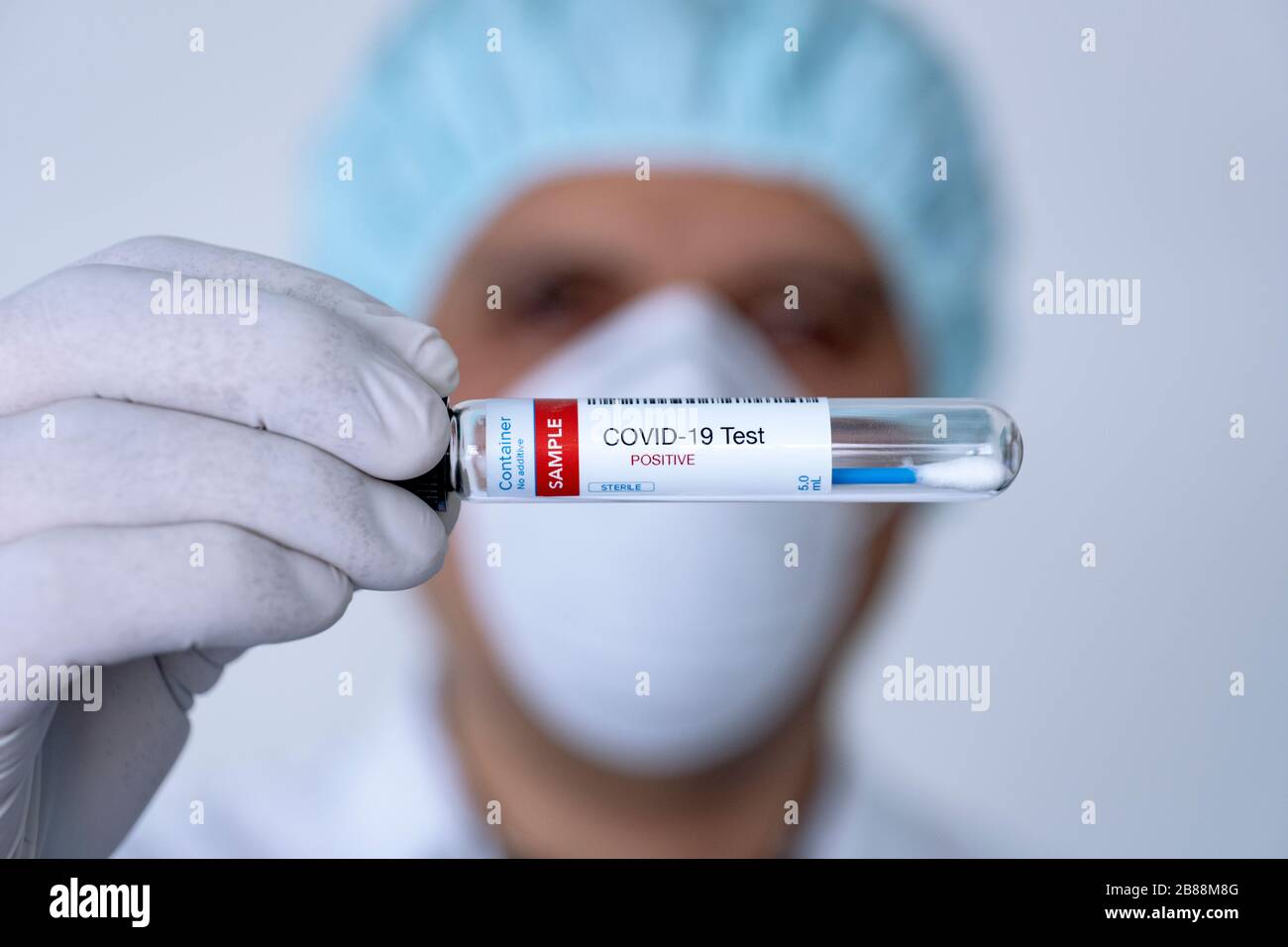 Testing for presence of coronavirus. Doctor holding a tube containing a swab sample for COVID-19 that has tested positive. Stock Photo