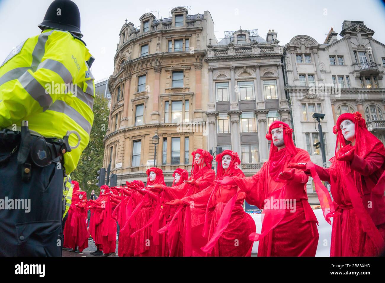 Whitehall, London, UK. - October 7, 2019 - Extinction Rebellion ptotests - 'Red Brigade' art group during a street performance on Trafalgar Square Stock Photo