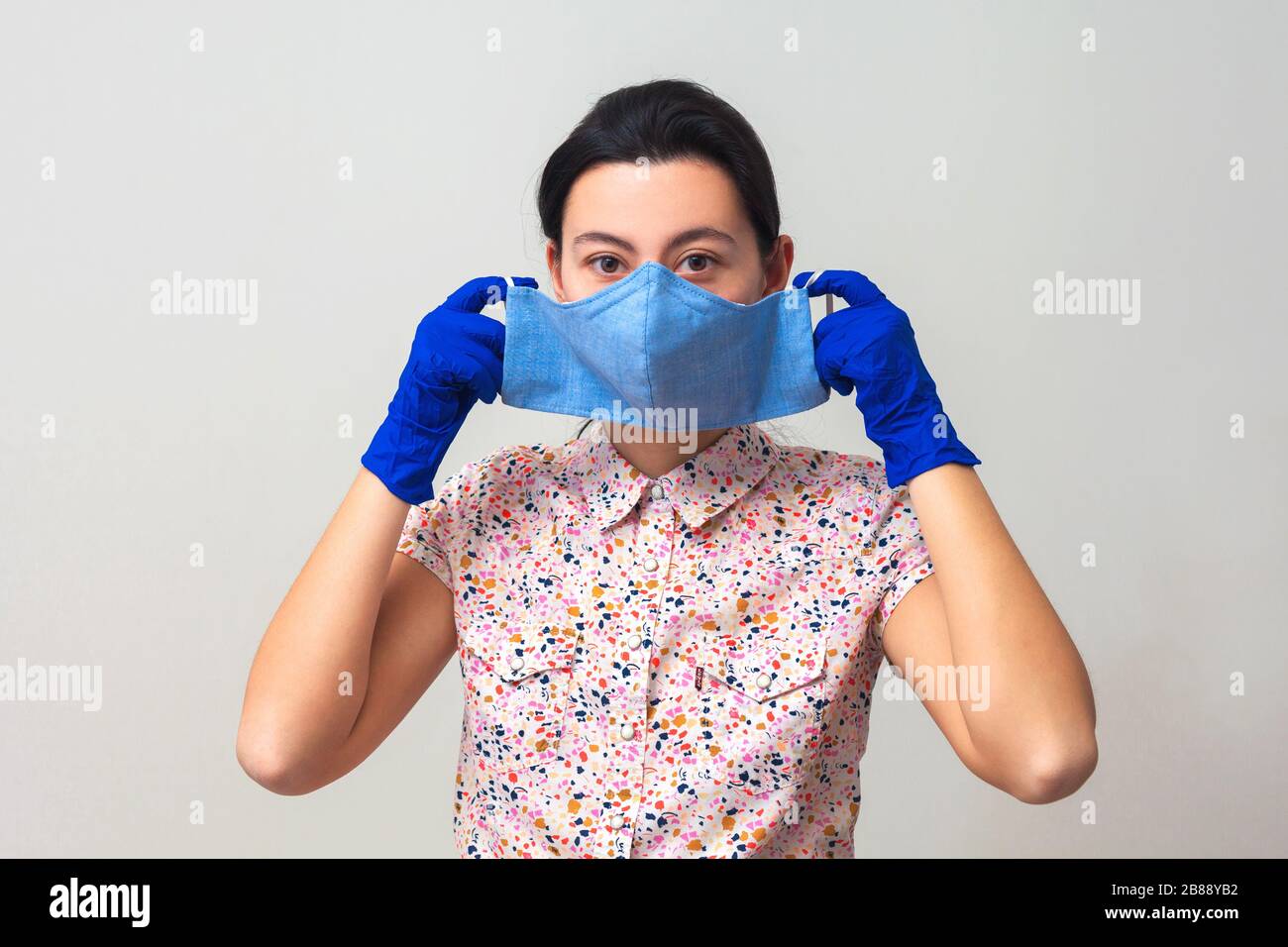 The girl in gloves puts on a medical mask. Prevention of viral diseases ...