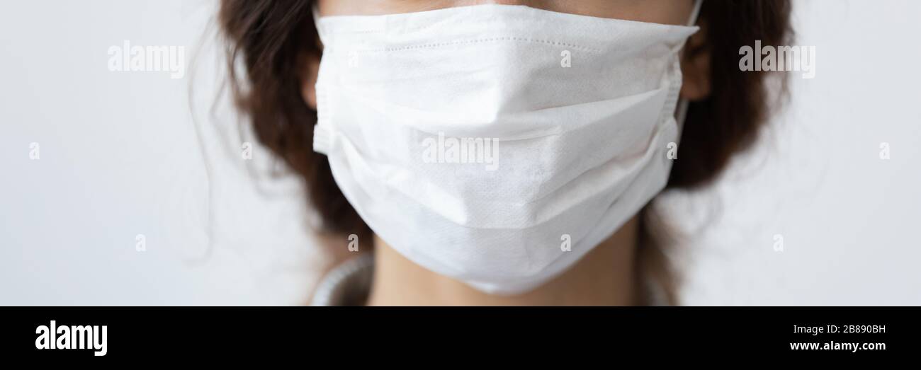 Closeup cropped horizontal image woman wear mask on blue background Stock Photo