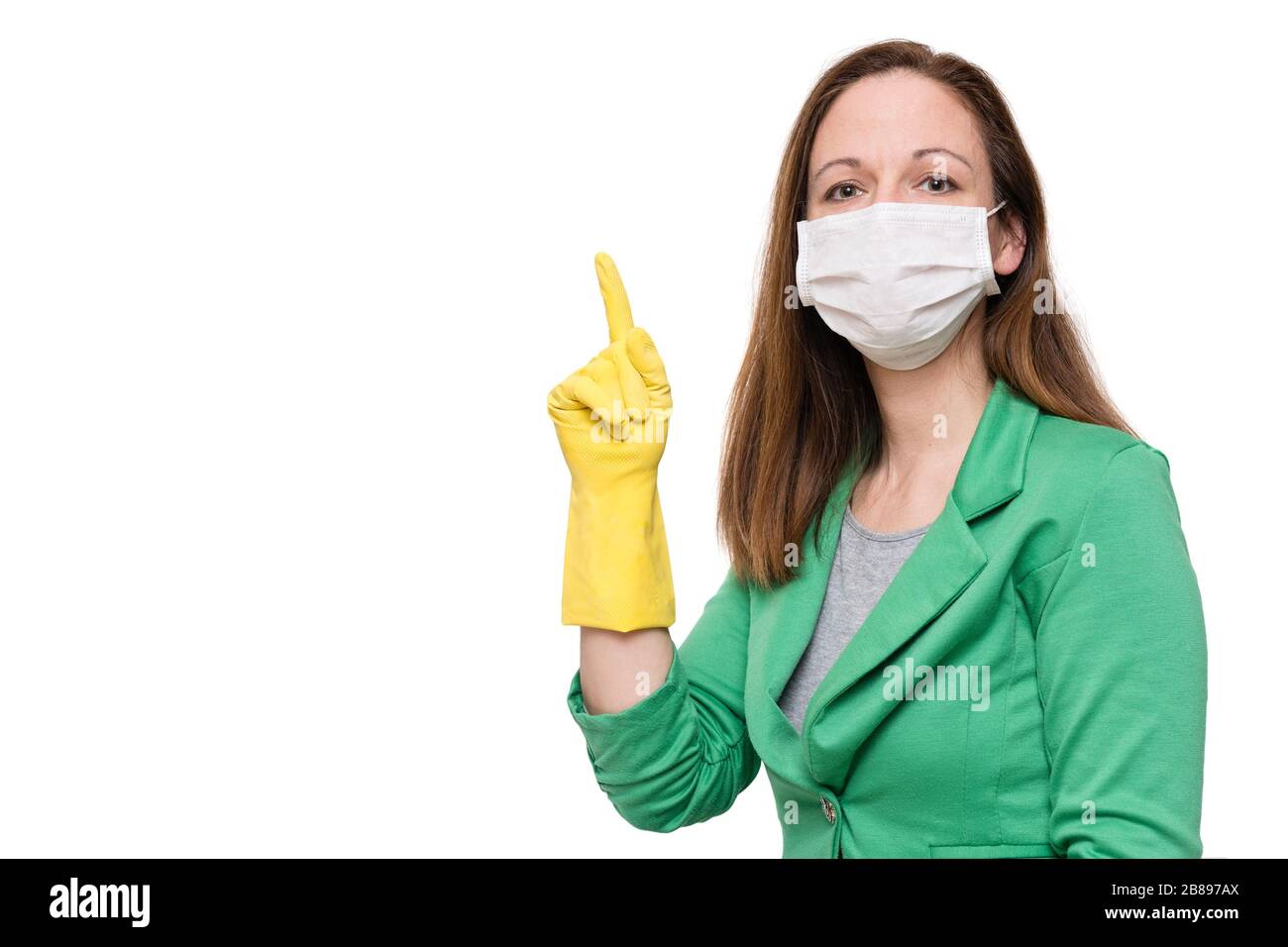 Portrait of young woman with face mask and yellow gloves pointing finger up, isolated on white background Stock Photo