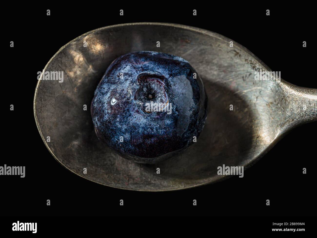 Frozen blueberry on teaspoon. Stock Photo