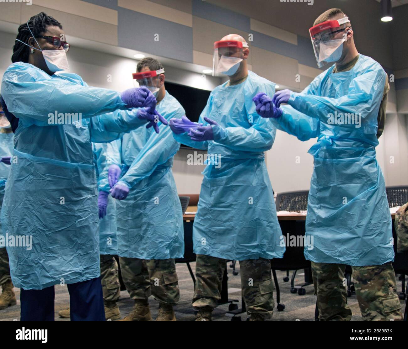 Florida National Guard members are trained in donning personal protective equipment by hospital staff at a COVID-19 testing facility March 17, 2020 in Broward County, Florida. Stock Photo