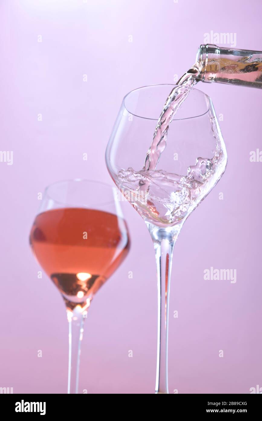 A concept studio image of pouring rose wine into a wine glass. Stock Photo