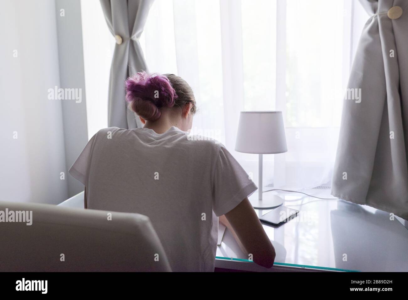 Girl Sitting At Desk Near Window Back View Student Studying At Home Stock Photo Alamy