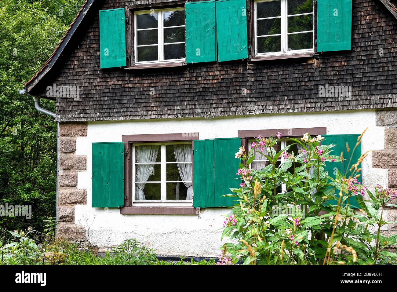 exterior of quaint old cottage with green shutters Stock Photo - Alamy