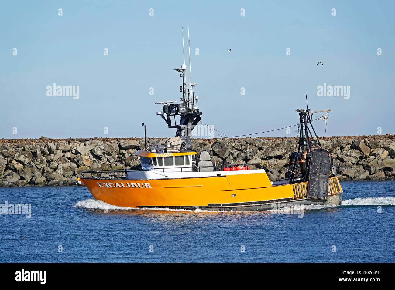A large, brightly colored commercial fishing boat sails through the