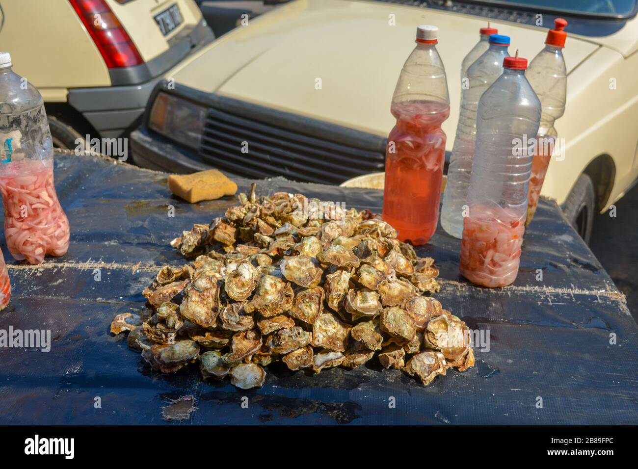A pile of fresh and delicious oysters. Delicacy from the Ocean, fine and expensive sea shells freshly caught. Displayed on the table of a market with Stock Photo