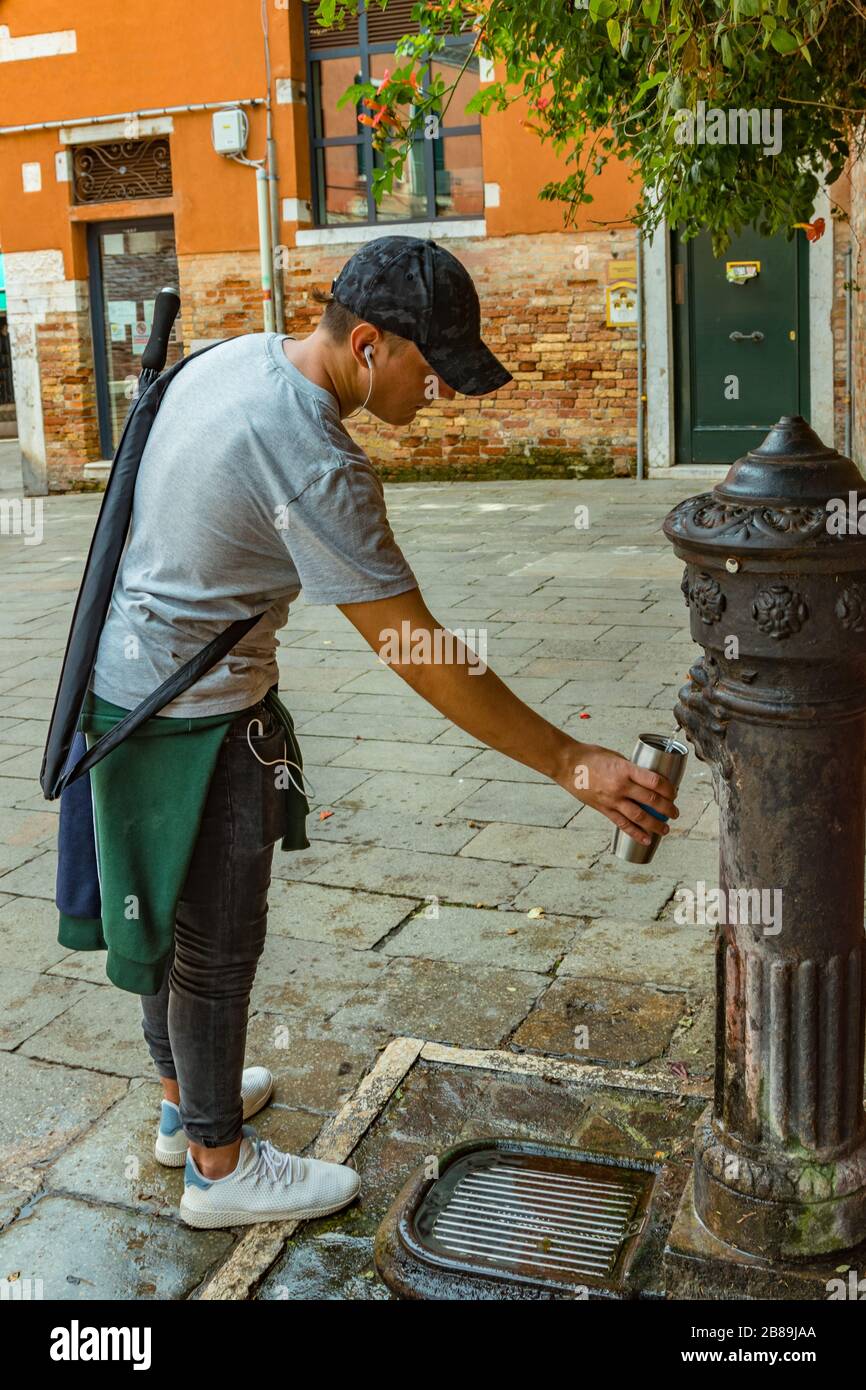 https://c8.alamy.com/comp/2B89JAA/man-filling-metal-flask-thermos-using-old-bronze-public-street-tap-for-fresh-water-traditional-drinking-water-fountain-venice-italy-2B89JAA.jpg