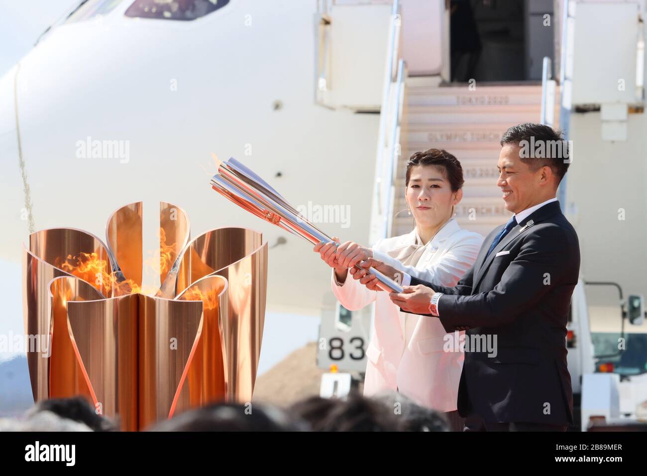 Higashi Matsushima, Japan. 20th Mar, 2020. Olympic gold medalists Saori Yoshida (L) of wrestling and Tadahiro Nomura (R) of judo light to a caldron with a torch as they attend the arrival ceremony for the Olympic flame at the Matsushima air base in Higashi Matsushima in Miyagi prefecture, northern Japan on Friday, March 20, 2020. Tokyo 2020 Olympic Games will start from March 26 at Fukushima prefecture. Credit: Yoshio Tsunoda/AFLO/Alamy Live News Stock Photo