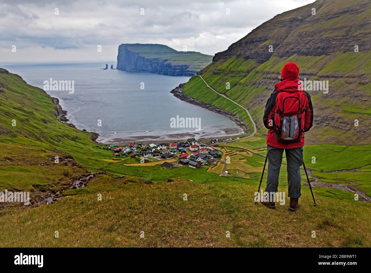 walker looking down onto the small village Torshavn and the Atlantic Ocean, Faroe Islands, Streymoy, Torshavn Stock Photo