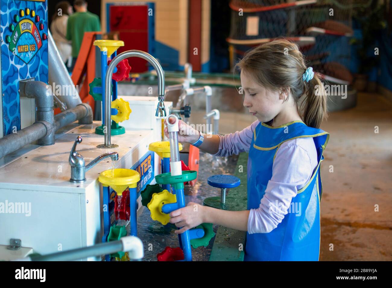 An indoor water table teaches a young girl about connection, direction, engineering and