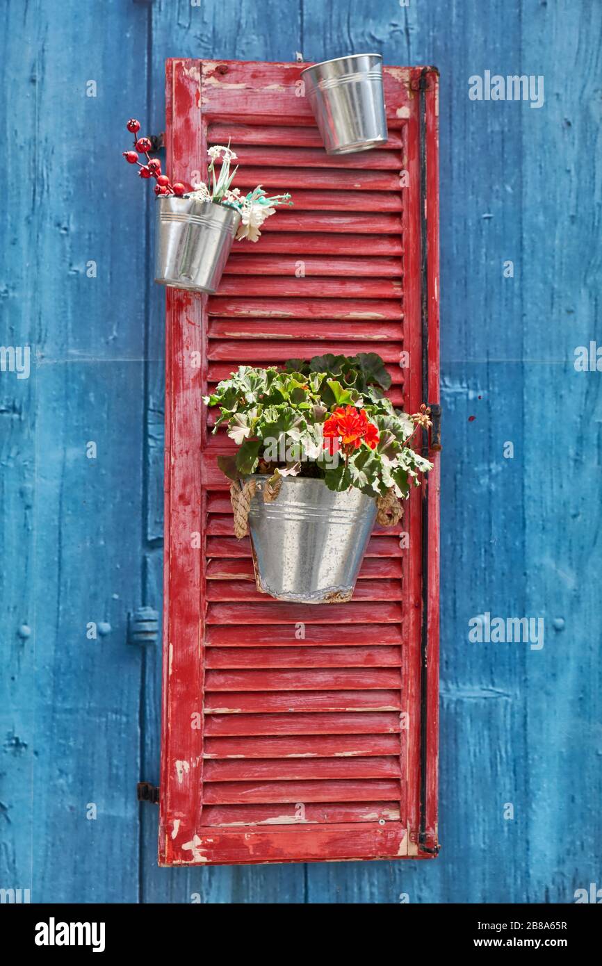 The decorative red wood plant holder on the blue wall of old house in the Pano Lefkara village. Cyprus Stock Photo