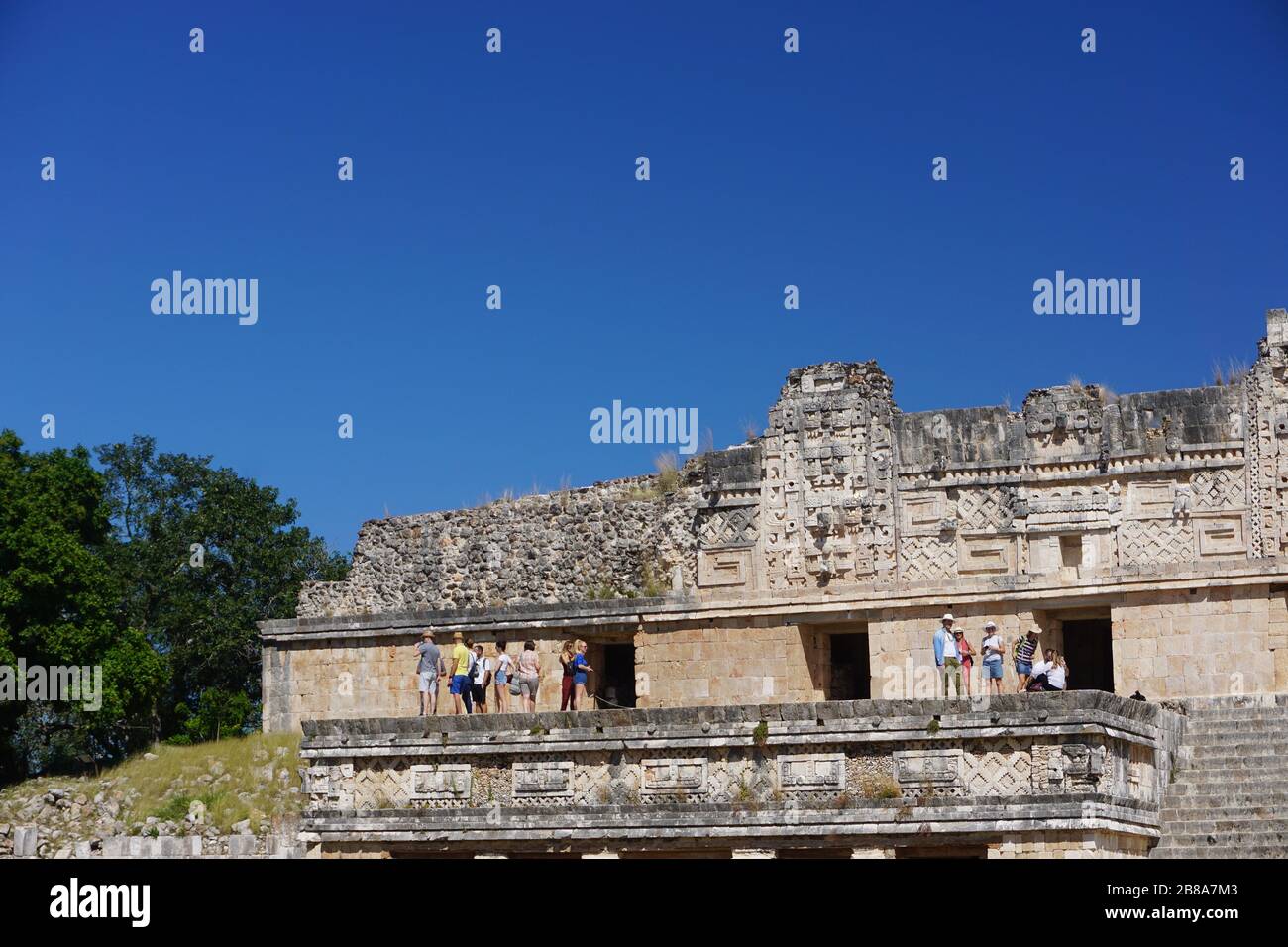 Uxmal, Mexico: Tourists visiting the Mesoamerican ball court at the ancient Mayan ruins of Uxmal. Stock Photo