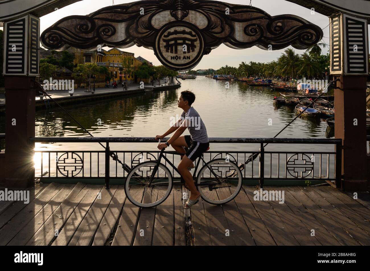Cyclist riding over the Japanese Covered Bridge, Hoi An, Vietnam Stock Photo