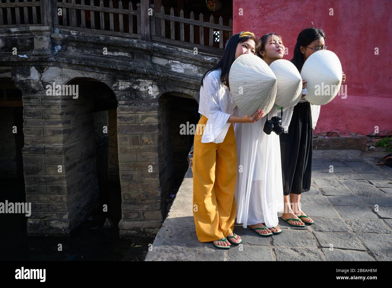 Young Vietnamese tourists posing with conical hats, Hoi An, Vietnam Stock Photo