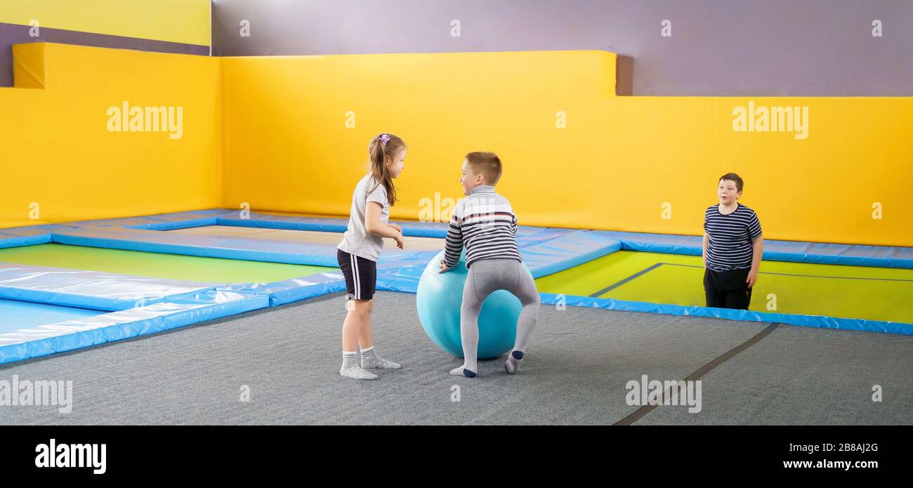 Happy smiling small kids jumping on indoors trampoline in entertainment ...