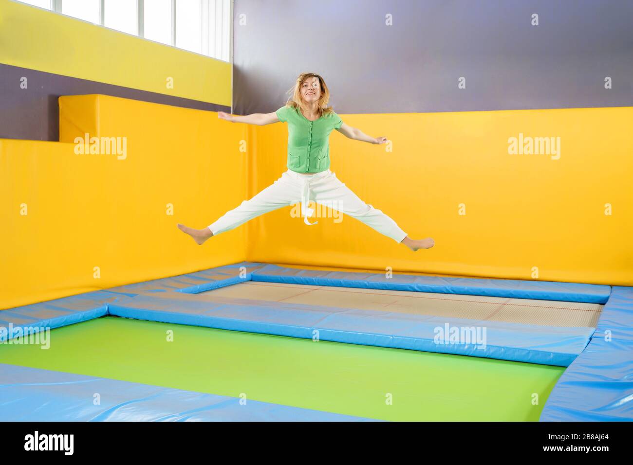 Young girl jumping on a trampoline in sport center Stock Photo Alamy