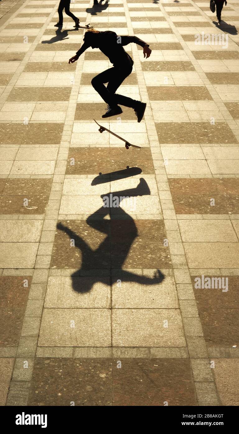 Silhouette of skateboarder skateboarding at sunrise city town Stock ...