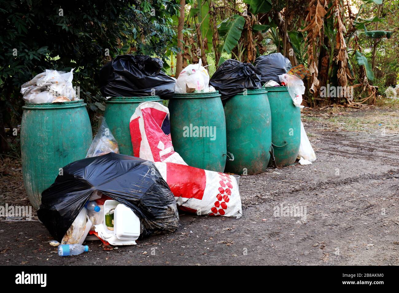 https://c8.alamy.com/comp/2B8AKM0/bin-bin-trash-and-many-pile-of-garbage-bags-on-the-ground-bin-waste-plastic-for-recycle-garbage-waste-many-pollution-waste-in-village-2B8AKM0.jpg