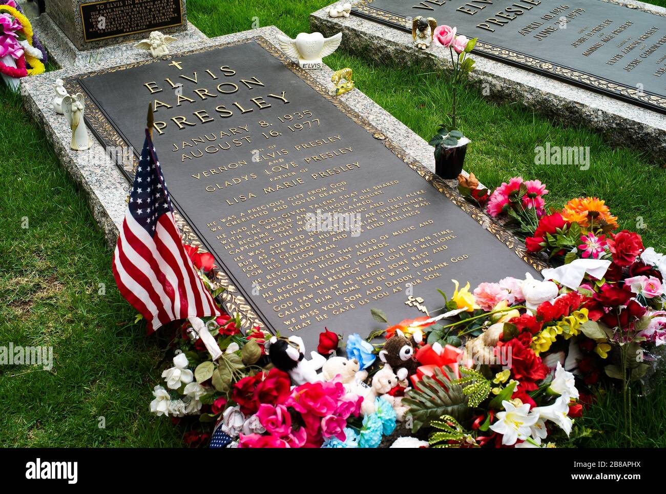 Memphis, Tennessee, United States - July 21 2009: The Grave of Elvis Presley in Graceland decorated with Flowers and a Flag. Stock Photo