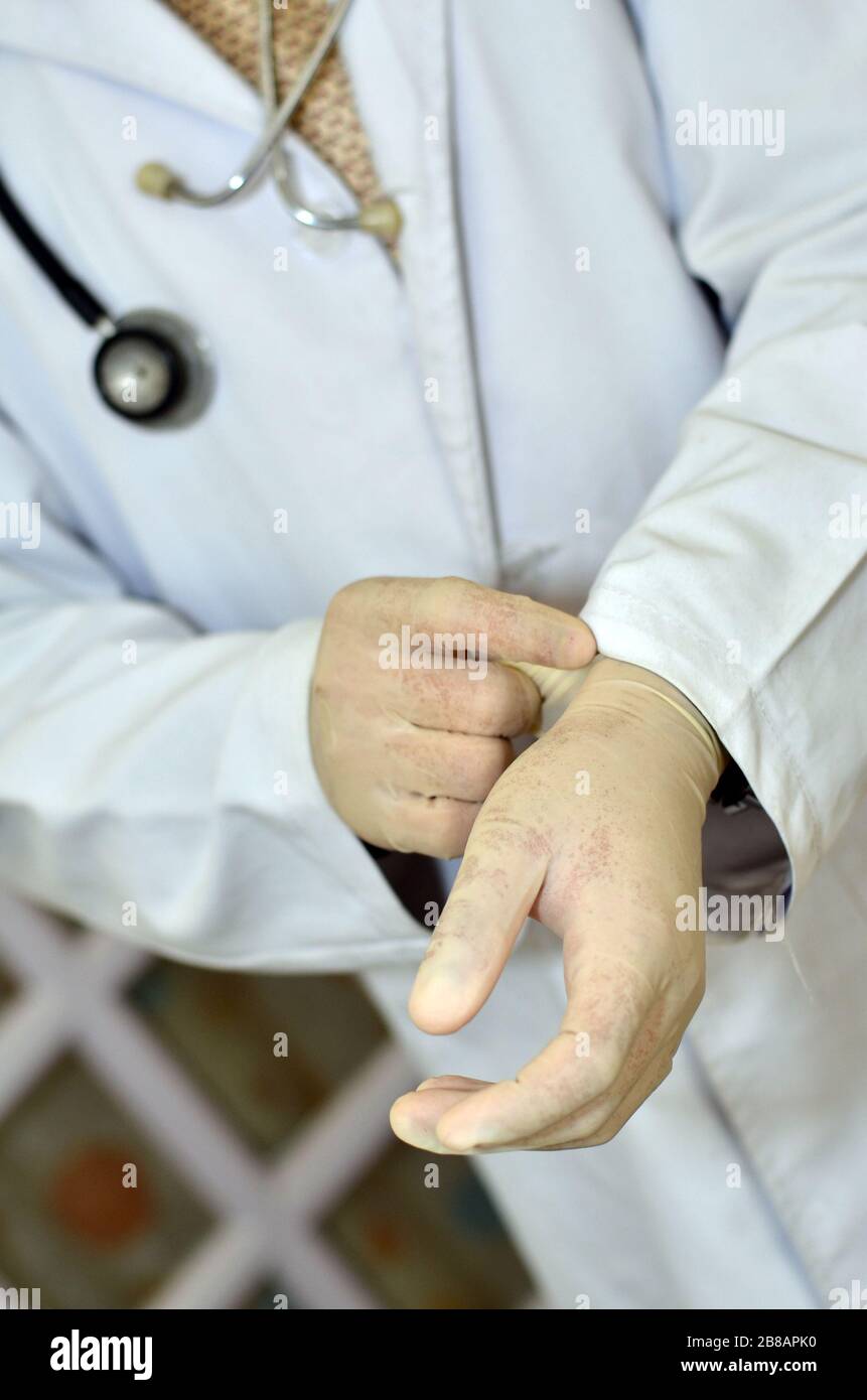 A doctor wearing hand gloves for germ protection Stock Photo