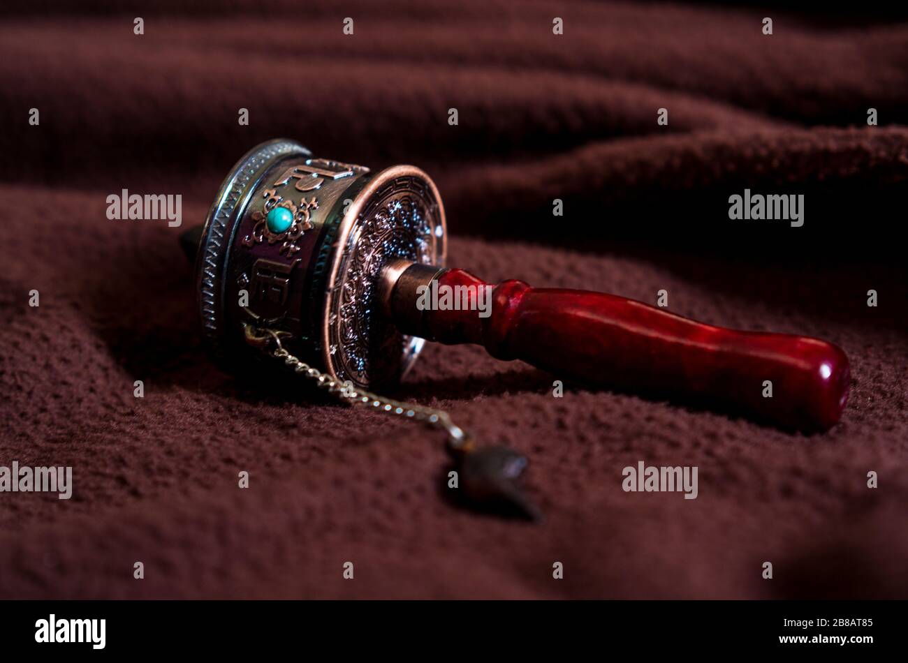 A prayer wheel is a 'wheel' on a spindle made from metal, wood, leather, or even coarse cotton. On the wheel are depicted or encapsulated prayers. Stock Photo