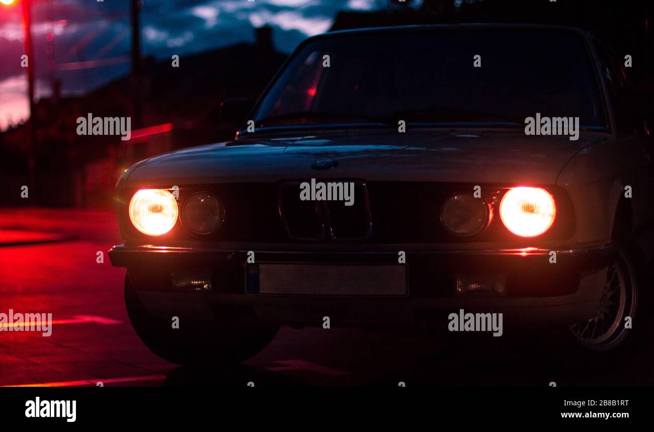 Car with glowing lights at night parked on the street Stock Photo Alamy
