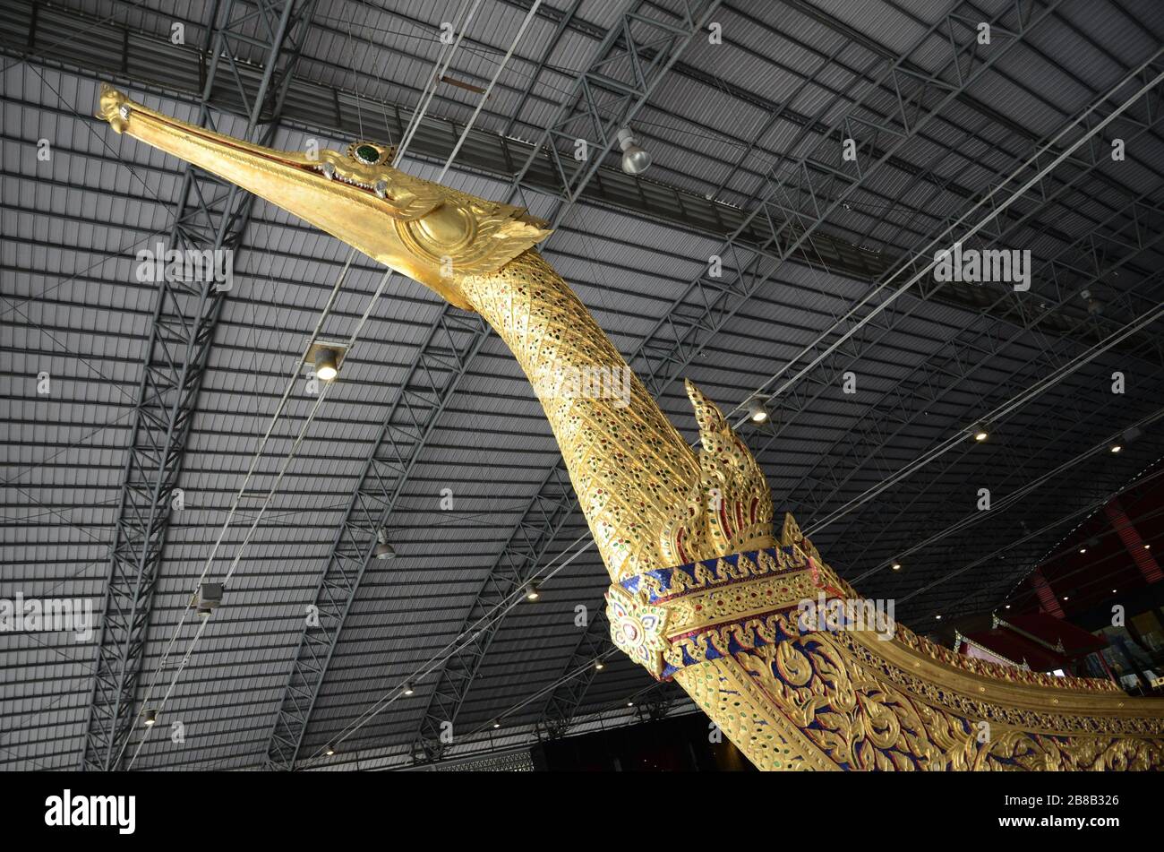 Golden statue of an animal decorated with multiple colors under the roof of a building Stock Photo