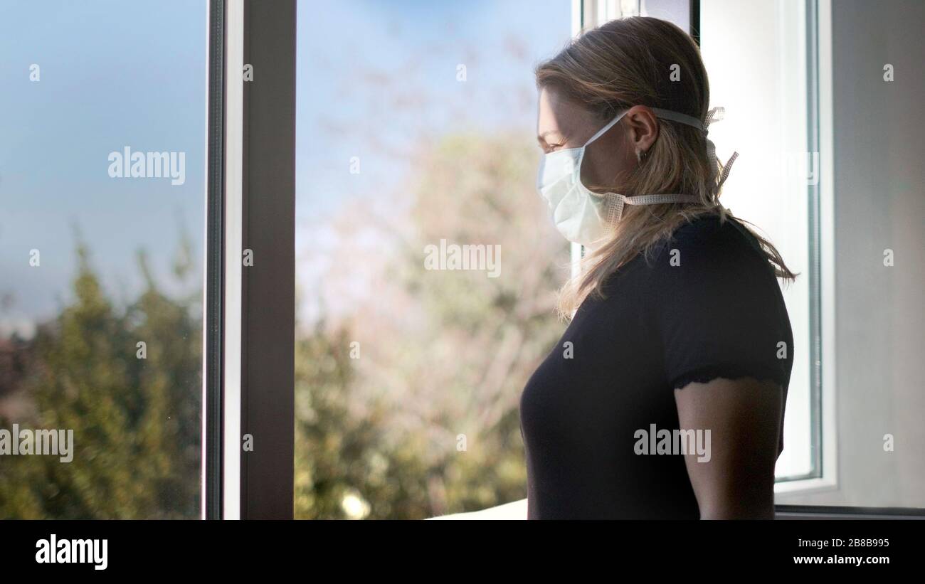 horizontal background of woman in isolation opening window taking fresh air against virus outbreak hypochondria Stock Photo