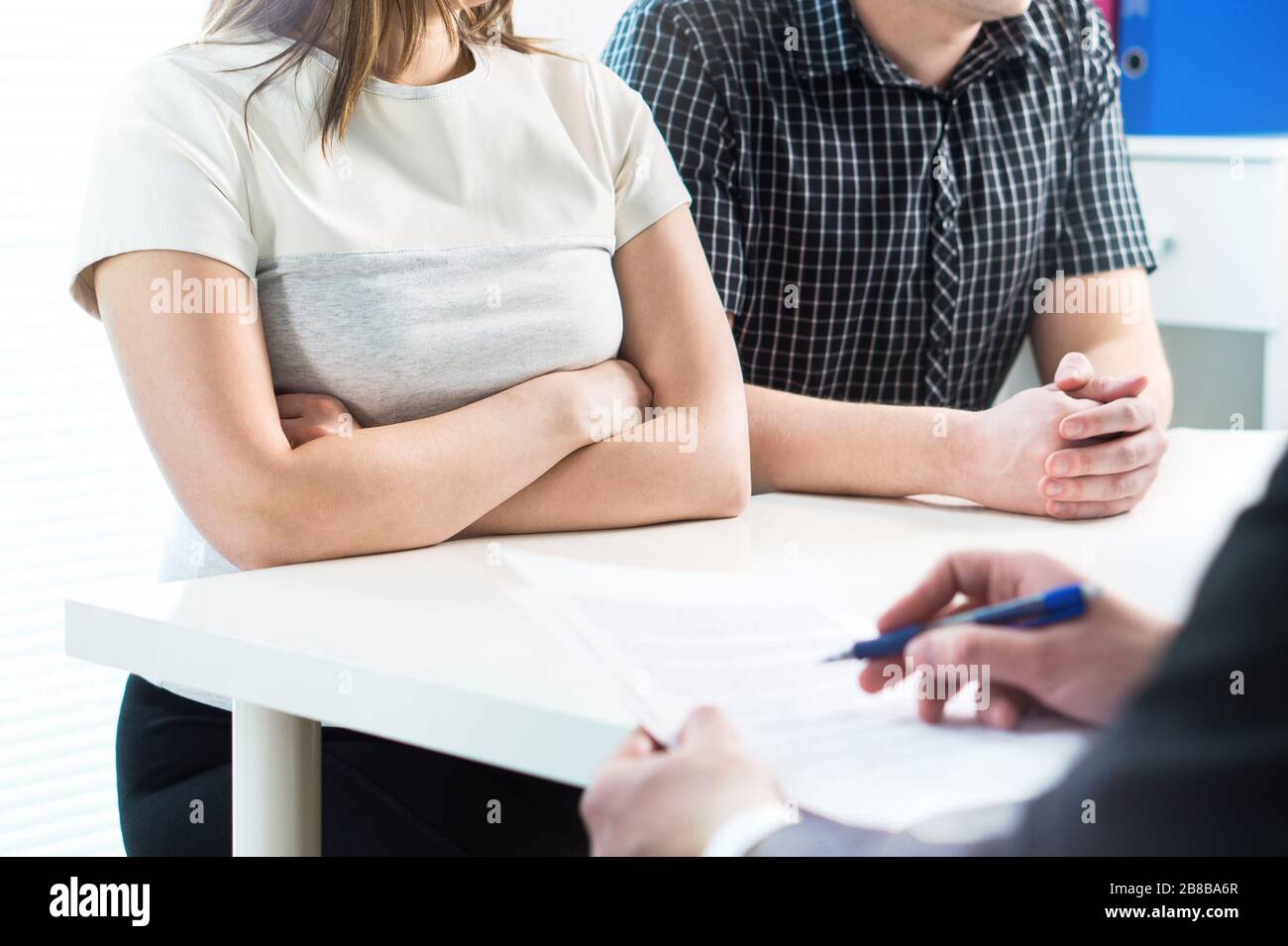 Unhappy couple in meeting with therapist, psychologist, divorce lawyer or legal consultant. Upset woman and man having fight in therapy session. Stock Photo