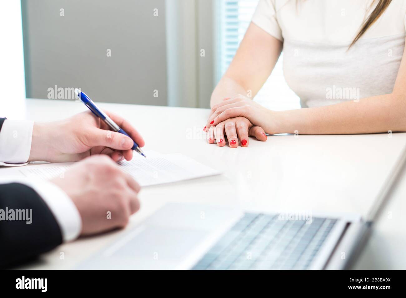 Young woman in job interview with business man. Interviewer writing notes. Lady having meeting with boss or executive manager. Stock Photo